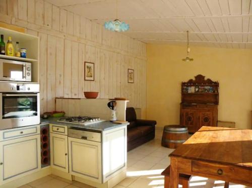 a kitchen with a stove top oven next to a living room at Maison de 3 chambres avec piscine partagee jardin amenage et wifi a Le Buisson de Cadouin in Le Buisson de Cadouin