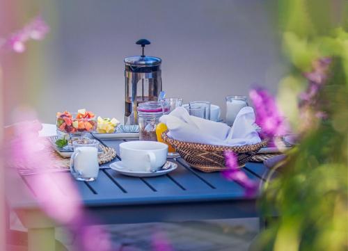 una mesa con comida y tazas en una mesa azul en Airlies Historical Guest House, en Montagu