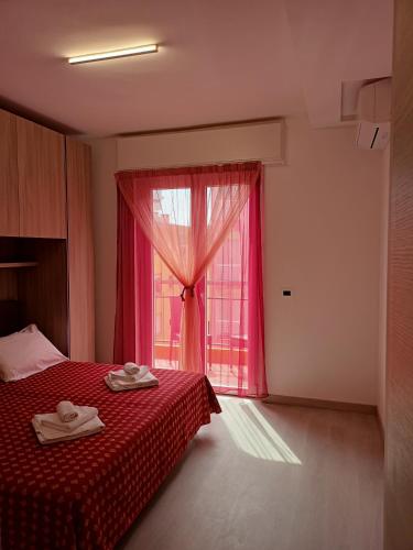 a bedroom with a red bed and a window at Residence Carlo in Grado