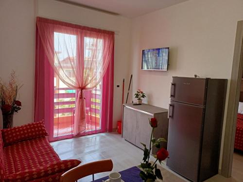 a living room with a red couch and a refrigerator at Residence Carlo in Grado