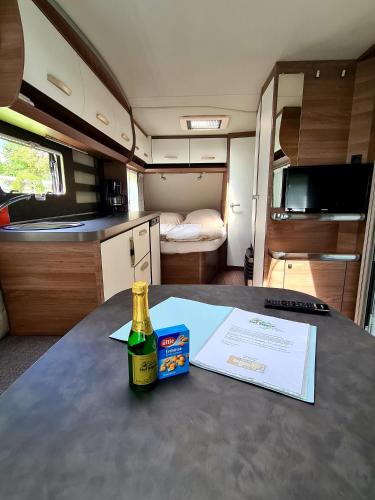 a bottle of champagne sitting on a table in an rv at Campingplatz Hof Biggen in Attendorn