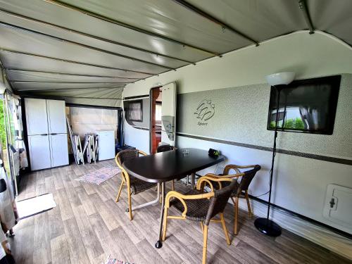 un comedor con mesa y sillas en un remolque en Campingplatz Hof Biggen, en Attendorn