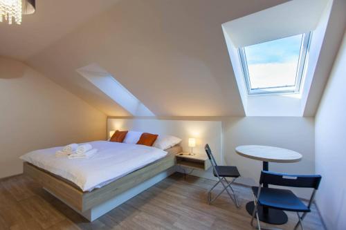 a bedroom with a bed and a table and a window at Penzion a restaurace Feldsberg in Valtice