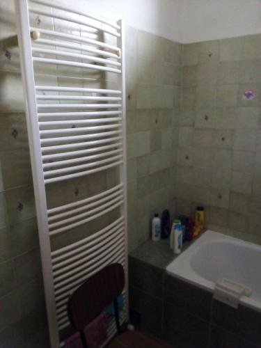a bathroom with a tub and a chair next to a sink at Öregakác Vendégház in Tiszaladány