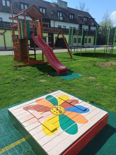 a playground with a slide and a slideintend at Hotel Jestřábí in Černá v Pošumaví