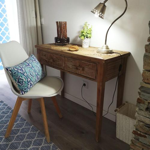 a wooden desk with a chair and a lamp at Quinta das Levadas - Country House & Nature in Alvoco das Várzeas