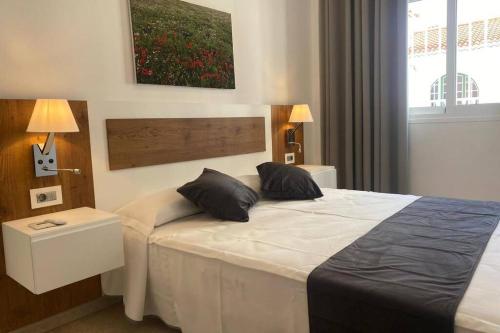 een slaapkamer met een bed met twee kussens erop bij Kalma IV in La Restinga