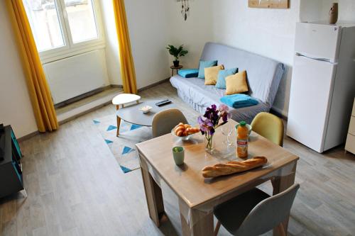 un salon avec une table et un canapé dans l'établissement Appartement le Mimosa - Apparts Cosy, à Villeuneuve-de-Berg