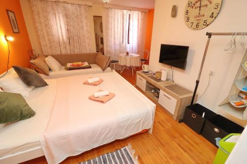 a living room with a large bed and a tv at Guest House Jungher in Korčula