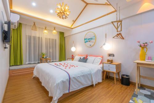a bedroom with a white bed with red flowers on it at Tongli Slowlife River View Inn in Suzhou