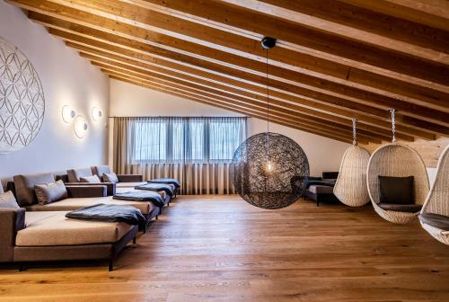 a living room with couches and a wooden ceiling at Damülser Hof - Wellness & Spa in Damuls