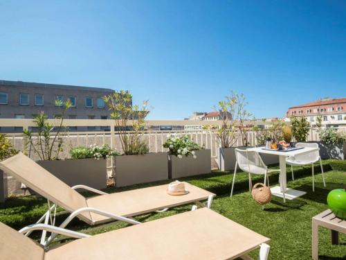 d'une terrasse avec une table et des chaises sur gazon. dans l'établissement Novotel Marseille Centre Prado Vélodrome, à Marseille