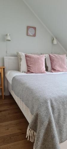 a bedroom with a bed with pink pillows at Home away home in Tartu