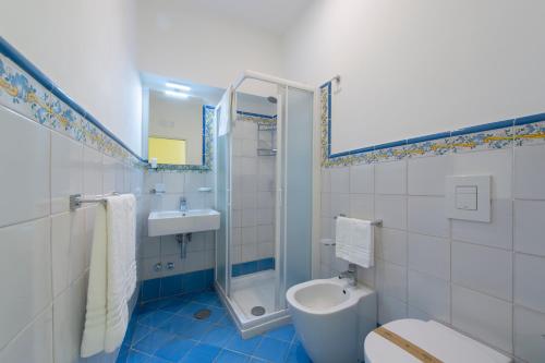a bathroom with a toilet and a shower and a sink at Ravello House in Ravello