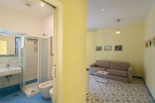 a living room with a couch and a bathroom at Ravello House in Ravello