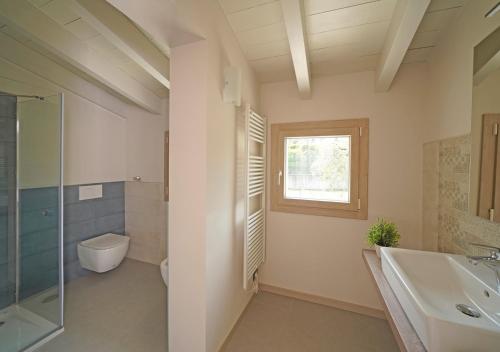 a bathroom with a sink and a toilet and a window at Gardaliva 5 in Manerba del Garda