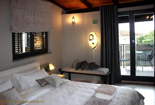 a bedroom with a bed and a balcony with a table at URBAN VILLA APARTMENT in Opatija