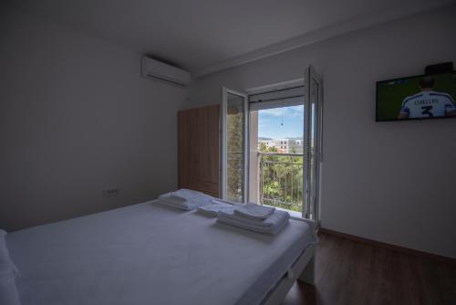 Cette chambre blanche dispose d'un lit et d'une fenêtre. dans l'établissement Apartman Arijana, à Trebinje