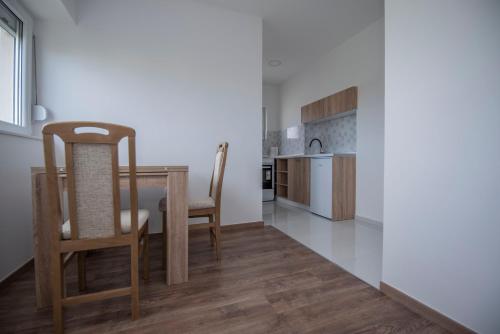 - une cuisine et une salle à manger avec une table et des chaises dans l'établissement Apartman Arijana, à Trebinje