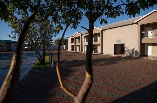 
a building with a tree in front of it at Lefa Boutique Hotel in Rustenburg
