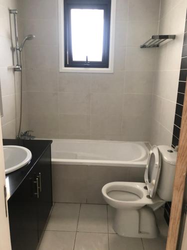 a bathroom with a toilet and a tub and a sink at Modern Luxury Apartment in the heart of Nicosia in Nicosia