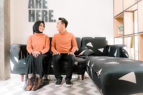 a man and woman sitting on chairs in a salon at Happy House BnB Bromo backpacker in Probolinggo