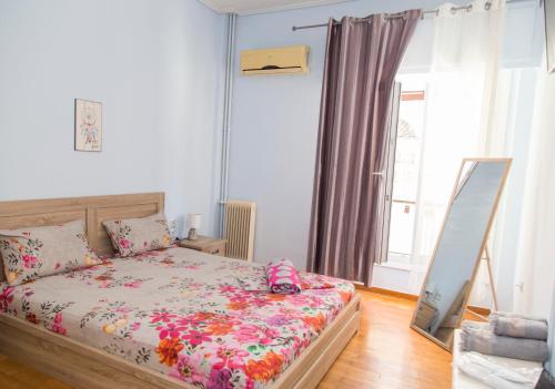 una camera da letto con un letto con copriletto floreale di aris apartment a Nauplia