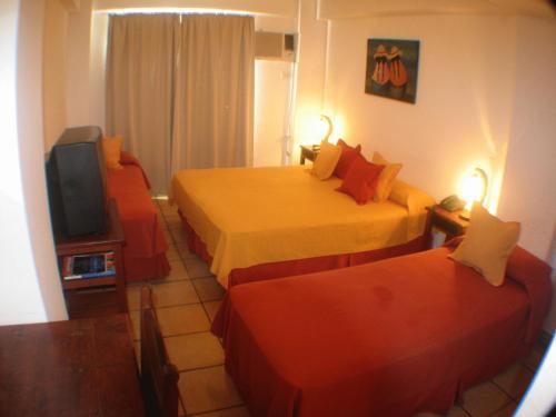 a hotel room with two beds and a tv at Altoparque Hotel Salta in Salta