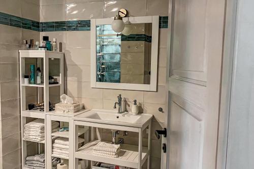 a white bathroom with a sink and a mirror at JAVOR - Rezidence & Wellness in Železná Ruda