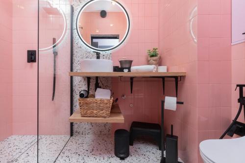 a pink bathroom with a sink and a mirror at Gdansk Old Town Walowa Apartments by Renters in Gdańsk