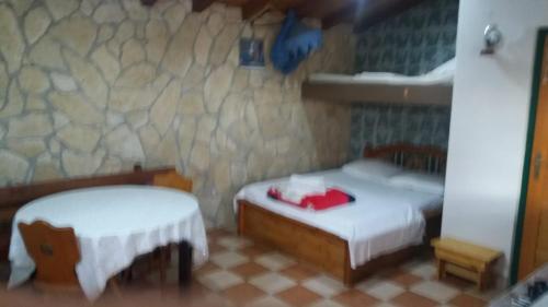 a bedroom with two beds and a stone wall at Magunja in Neviđane