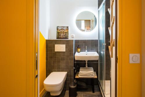 une salle de bain avec des toilettes blanches et un lavabo dans l'établissement MAISON FRANCOIS Paris, à Paris