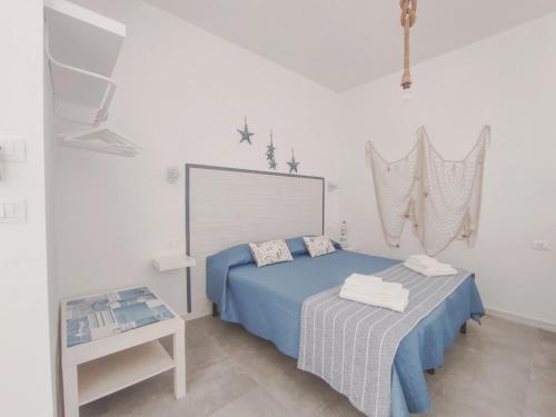 Un dormitorio con una cama azul y una mesa en A Casa di Rosanna, en Vieste
