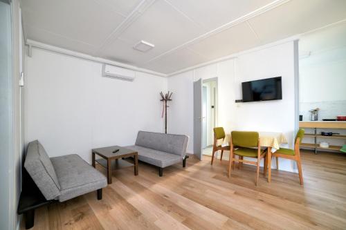 a living room with a table and chairs and a tv at Parti Üdülő in Tiszaalpár