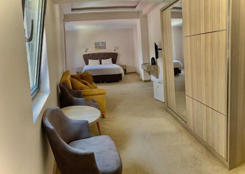 a hotel room with a bed and a couch and chairs at Platinium Residence Mangalia in Mangalia