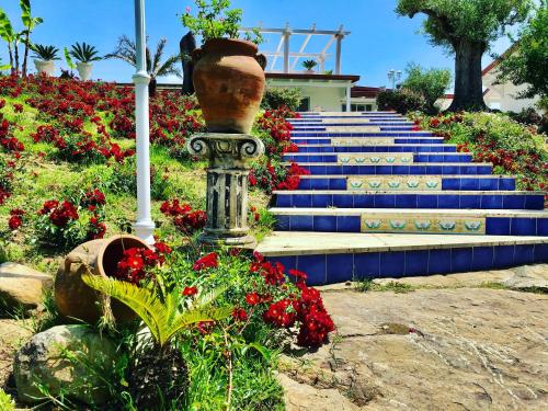 a set of stairs with red flowers and a vase at L'incanto di Nausicaa in Ascea