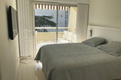 - une chambre avec un lit et un balcon dans l'établissement Luxueux appartement central proche Croisette, à Cannes