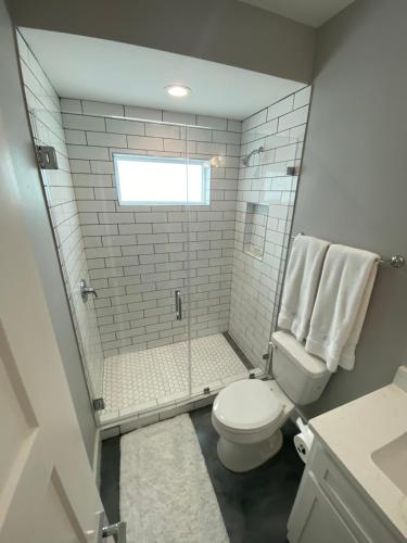 a bathroom with a toilet and a glass shower at Gulf-View, New-Build w/ Pool, & EV Charging in Port Aransas