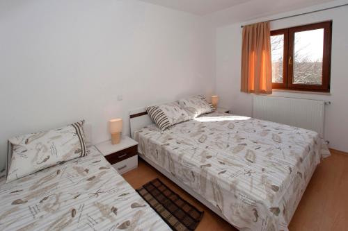 a bedroom with two beds and a window at Holiday House Cukrići in Cukrići