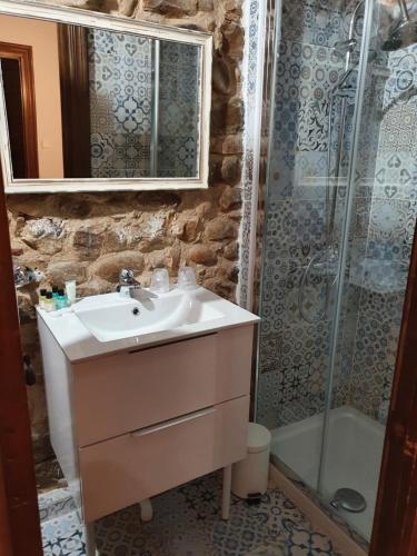 een badkamer met een wastafel en een douche bij Ermita 1883 in Puente San Miguel
