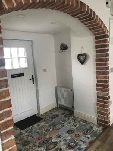 a room with a white door and a brick wall at Toddys Cottage & Stables in Cavan
