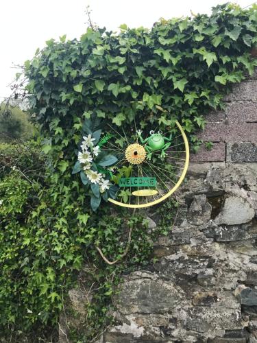a garden sign on a brick wall with flowers at Toddys Cottage & Stables in Cavan