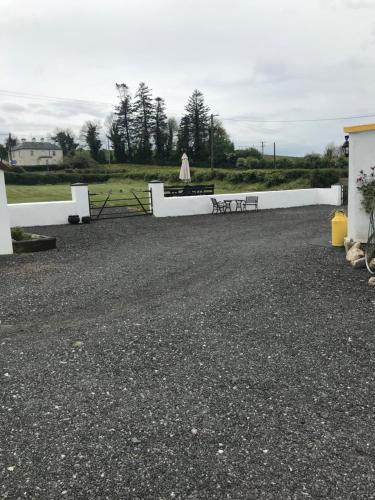 a parking lot with two benches and a white fence at Toddys Cottage & Stables in Cavan