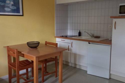 - une cuisine avec une table en bois et un bol dans l'établissement Studio très bien situé, belle vue, parking privé, à Bagnères-de-Bigorre