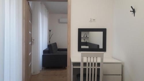 een woonkamer met een blauwe bank en een spiegel bij Apartament Kąty Rybackie Zaciszna in Kąty Rybackie