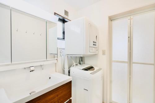 a white bathroom with a sink and a counter at Sali's House in Hakuba