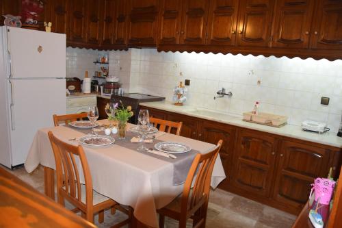 a kitchen with a table with chairs and a refrigerator at Naoussa Center Cycladic House in Kampos Paros