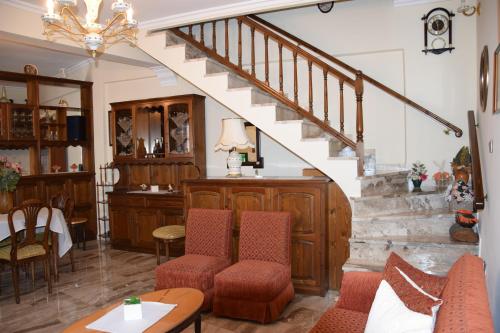 a living room with a staircase and a table and chairs at Naoussa Center Cycladic House in Kampos Paros