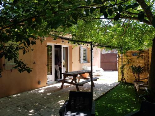 eine Terrasse mit einem Tisch und einer Schaukel in der Unterkunft le petit st Jean in Cazouls-d Herault