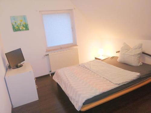 a small bedroom with a bed and a window at Katzensprung zum Wald in Malchow